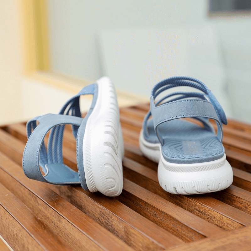 Blue sport women's soft sandals with Velcro on wooden bench, featuring PU leather and TPR outsole for comfort and style.